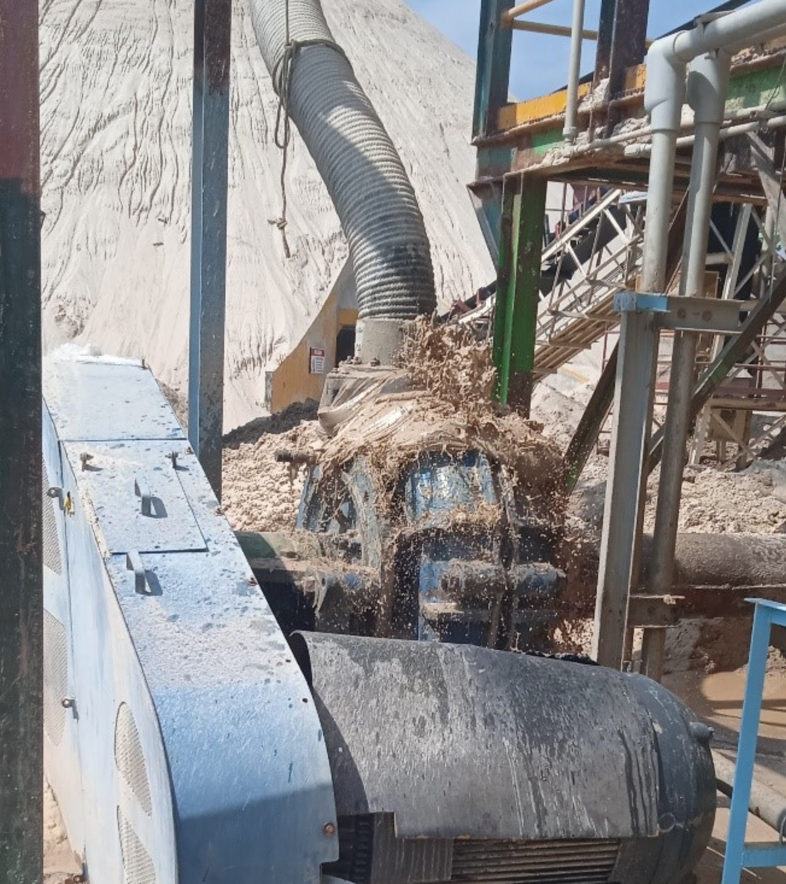 Bomba para lodos operando en campo con descarga de pulpa alrededor del equipo de bombeo.